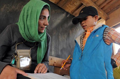 Malal Loynab, a Human Terrain Analyst with Combined Joint Task Force 101, teaches an Afghan child English during a new literacy program, which she helped start at the Egyptian Field Hospital here Oct. 28th. (Photo by U.S. Army Staff Sgt. Whitney Hughes, Task Force Wolverine Public Affairs, 86th Infantry Brigade Combat Team (Mountain))