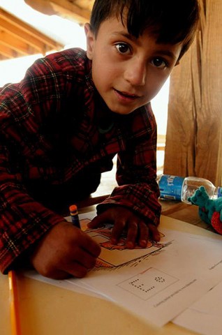 An Afghan child participates in a new literacy program at the Egyptian Field Hospital here Oct. 28th. (Photo by U.S. Army Staff Sgt. Whitney Hughes, Task Force Wolverine Public Affairs, 86th Infantry Brigade Combat Team (Mountain))