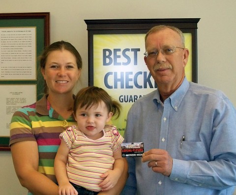 Planters Bank VP and Sango Branch Manager Fred Slack (right) presents a $100 Loyal-T-Fuel gas card to Cube finalist Penny Goddard and daughter Savannah.