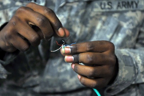 U.S. Army Pfc. Derek A. Gamlin of Kosciusko, MS, a Task Force Bastogne information management officer with Headquarters and Headquarters Company, TF Bastogne’s communication shop, fixes an internet cable Oct. 19th. (Photo by U.S. Army Spc. Richard Daniels Jr., Task Force Bastogne Public Affairs)