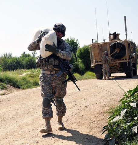 U.S. Army Sgt. 1st Class Derek L. Ashman, of San Diego, a platoon sergeant with 1st Platoon, Company D, 2nd Battalion, 327th Infantry Regiment, Task Force Spartan, carries a bag rice to be given to a local farmer Sept. 26th. The rice was given to the farmer to compensate him for damages caused to his crops by a U.S. Army vehicle earlier in the month in Goshta District in eastern Afghanistan’s Nangarhar Province. (Photo by U.S. Army Sgt. Albert L. Kelley, 300th Mobile Public Affairs Detachment)