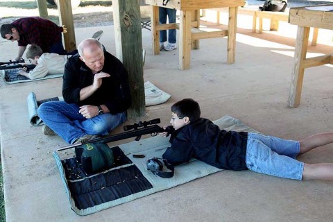 Dave Davis (center) instructs Boy Scout Jared Barham on a Fort Campbell firing range Oct. 16th. Scouts from the Middle Tennessee Council received weapons training from volunteers to earn their Rifle Merit Badge.  (Photo by Spc. Kelly Fox) 