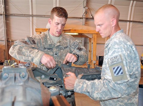 U.S. Army Sgt. Craig Hayward, powertrain mechanic and native of Huntingtown, MD, assigned to Company D, Task Force Viper works to disassemble a rotor head from an AH-64 Apache helicopter on Forward Operating Base Salerno while U.S. Army Sgt. James Elliot, turbine engine mechanic from Millbrook, AL, assigned to D Co., TF Viper, provides assistance. (Photo by U.S. Army Staff Sgt. Brent C. Powell, 3rd Brigade, 101st Airborne Division)