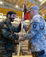 U.S. Army Brig. Gen. Warren Phipps (right), deputy commanding general (support) for the 101st Airborne Division, passes the Combined Action Program guidon to Afghan Brig. Gen. Mohammed Barat, Kabul Wing commander of the Afghan Air Force. (Photo by U.S. Army Sgt. Monica K. Smith, 3rd Combat Aviation Brigade, Task Force Falcon)