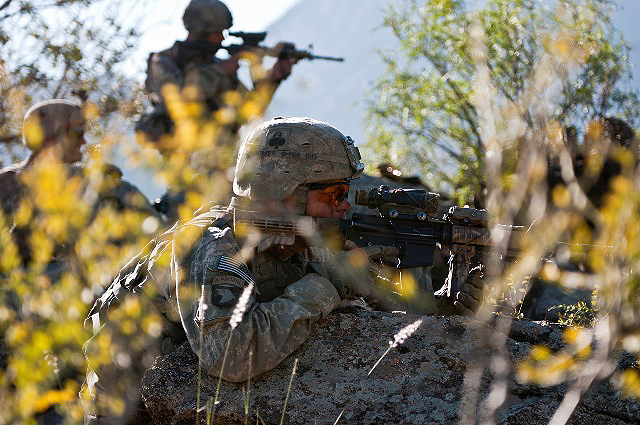 U.S. Army Sgt. James T. Schmidt, an infantry squad leader from Decatur, IL, and other Soldiers with Task Force No Slack, get a closer view from their fighting position on a remote hilltop in the Shal Valley in eastern Afghanistan’s Nuristan Province of a ridge line while providing cover for a combat logistics patrol Nov. 9th. (Photo by U.S. Army Staff Sgt. Mark Burrell, 210th Mobile Public Affairs Detachment)