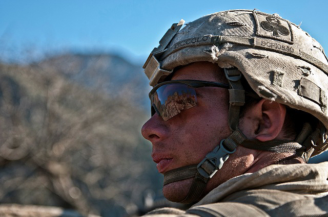 U.S. Army Spc. James Piccolo, an MK48 assistant gunner from Longview, WA, Task Force No Slack, looks over his shoulder for insurgent activity from his fighting position on a remote hilltop in the Shal Valley in eastern Afghanistan’s Nuristan Province Nov. 8th. (Photo by U.S. Army Staff Sgt. Mark Burrell, 210th Mobile Public Affairs Detachment)