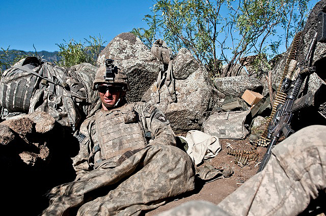 U.S. Army Pfc. Bobby A. Rey, an MK48 machine gunner from Mobile, AL, assigned to Company C, 2nd Battalion, 327th Infantry Regiment, Task Force No Slack, tries to get comfortable in his fighting position on a remote hilltop in the Shal Valley in eastern Afghanistan’s Nuristan Province Nov. 9th. (Photo by U.S. Army Staff Sgt. Mark Burrell, 210th Mobile Public Affairs Detachment)