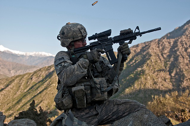 U.S. Army Spc. Brit B. Jacobs, a combat medic from Sarasota, FL, assigned to Company C, 2nd Battalion, 327th Infantry Regiment, Task Force No Slack, fires his M4 rifle from a remote hilltop in the Shal Valley in eastern Afghanistan’s Nuristan Province Nov. 7th at the beginning of an eight-hour firefight against insurgents. (Photo by U.S. Army Staff Sgt. Mark Burrell, 210th Mobile Public Affairs Detachment)