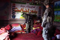 U.S. Army Spc. Jerry Strunk from Anderson, IN, with E Company, 2nd Battalion, 506th Infantry Regiment, 4th Brigade Combat Team, 101st Airborne Division, assists an Afghan National Army soldier as he searches through a home in the Charbaran District here Oct. 27th during the largest combined air assault mission 4th Brigade has conducted this year in the province. (Photo by U.S. Army Spc. Lorenzo Ware, Task Force Currahee Public Affairs)