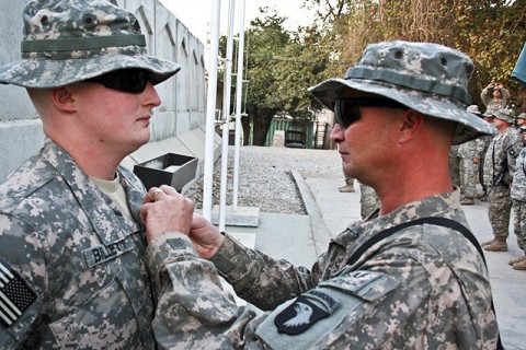 U.S. Army Sgt. William Billett (right), an infantryman with Company B, 2nd Battalion, 506th Infantry Regiment, pins the Purple Heart on the chest of his son, U.S. Army Sgt. Timothy Billett, a military policeman from Headquarters and Headquarters Company, 1st Special Troops Battalion, Thanksgiving Day on Forward Operating Base Finley Shields in eastern Afghanistan. (Photo by U.S. Army Staff Sgt. Ryan C. Matson, Task Force Bastogne Public Affairs)