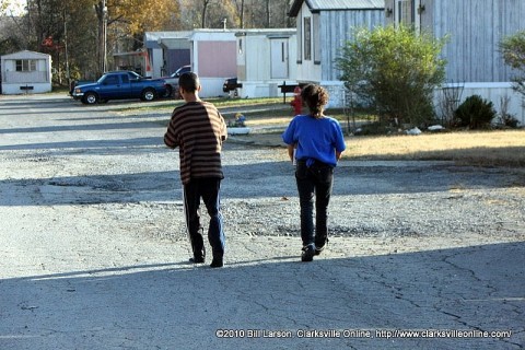 Two children walk towards their home with their Thanksgiving Food Basket and Turkey from H.O.P.E. in the Trailer Park on Powers Street on Friday