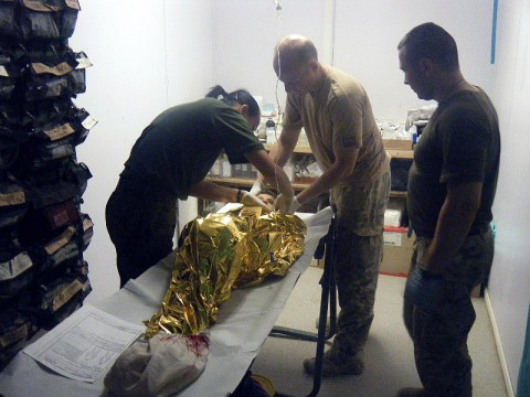 Doctors from Forward Operating Base Warrior prepare an 8-year-old Afghan girl for transportation to FOB Ghazni's field hospital for surgery. The girl was accidentally wounded by shooting between Taliban and Afghan security guards Nov. 2nd. (Courtesy photo)