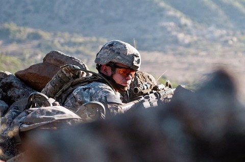 NURISTAN PROVINCE, Afghanistan – During a firefight with insurgents in the Shal Valley in eastern Afghanistan's Nuristan Province, U.S. Army Sgt. James T. Schmidt checks on his Soldiers from his fighting position on top of a mountain, Nov. 8th. “My grandfather was in the Merchant Marines and he’s really proud of me,” said Schmidt. “He’s really into what I’m doing here.” (Photo by U.S. Army Staff Sgt. Mark Burrell, 210th Mobile Public Affairs Detachment)