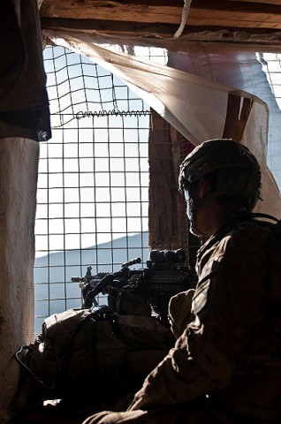 During a short break to eat and rest, U.S. Army Pfc. Chris J. Nielsen, from Huntington Beach, CA, assigned to Company B, 1st Battalion, 327th Infantry Regiment, Task Force Bulldog, stands guard at a window during joint clearing operations in the Pech River Valley in eastern Afghanistan's Kunar Province Nov. 25th. (Photo by U.S. Army Staff Sgt. Mark Burrell, Task Force Bastogne Public Affairs)