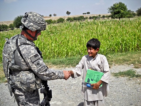 U.S. Army Staff Sgt. Robert Pharris, a ruminant specialist with the Khogyani District Agricultural Development Team attached to Company D, 1st Battalion, 138th Infantry Regiment from Mansfield, MO, talks with the son of an Afghan farmer in Chaparhar.  (Courtesy photo)