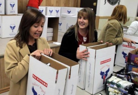 Family members of deployed soldiers out of Fort Campbell, KY share a laugh while stuffing care packages sponsored by Soldiers' Angels and BAE Systems on November 15th, 2010. The "packing party" is part of the first step in a process documenting the experiences of deployed soldiers and their families.