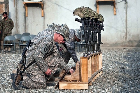 Soldiers kneel and leave memorabilia for their fallen comrades during a memorial service for six Soldiers from Abu Company, 1st Battalion, 327th Infantry Regiment (Task Force Bulldog), 1st Brigade Combat Team, 101st Airborne Division, at Combat Outpost Honikker Miracle in eastern Afghanistan’s Kunar Province Nov. 21st. (Photo by U.S. Army Staff Sgt. Mark Burrell, Task Force Bastogne Public Affairs)