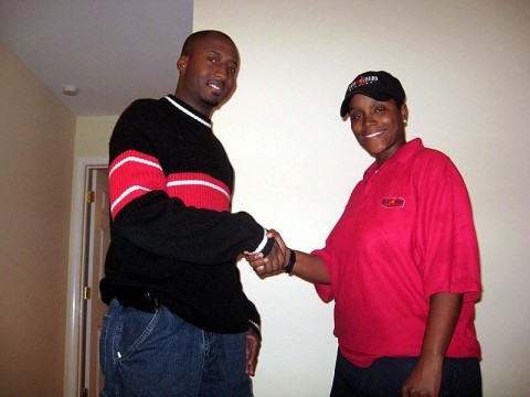 Richard "Reason" Garrett shaking hands with Sherry Walcott moments after entering her new home.