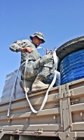 A McQueeney, Texas, native, U.S. Army Spc. Garrett Bartlett secures the load on his light medium tactical vehicle trailer with cargo straps Nov. 17th at Forward Operating Base Fenty before taking the drive back to FOB Connolly. (Photo by U.S. Army Staff Sgt. Ryan C. Matson, Task Force Bastogne Public Affairs)