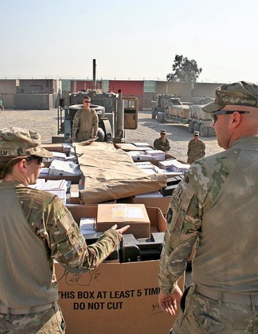 U.S. Army Sgt. Shannon Osterholm (left), U.S. Army Sgt. Cassidy Howard (far center), and U.S. Army Sgt. Jared Henkle (right), all truck drivers with the 2168 Transportation Detachment with Task Force Ironman, place a tarp over pallets of mail Dec. 18th at Forward Operating Base Fenty for a holiday mail convoy back to Forward Operating Base Mehtar Lam. (Photo by U.S. Army Staff Sgt. Ryan C. Matson, Task Force Red Bulls Public Affairs)