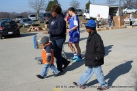 A woman and her two children walk back to their car after picking up a basket of food. A woman and her two children walk back to their car after picking up a basket of food.