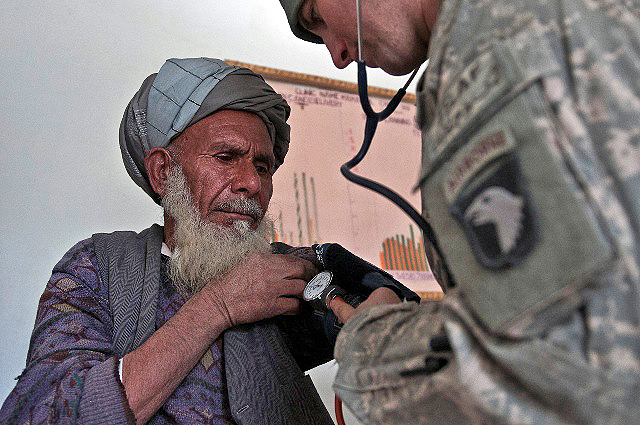 Gul Alam (left), an Afghan metalworker, gets checked out by U.S. Army Sgt. Robert A. Serrano, a combat medic from Staten Island, NY, Task Force Panther, during a free clinic in the Mannakhil Comprehensive Health Care Center in Sherzad District in eastern Afghanistan’s Nangarhar Province Dec. 26th. (Photo by U.S. Army Staff Sgt. Mark Burrell, Task Force Bastogne Public Affairs)