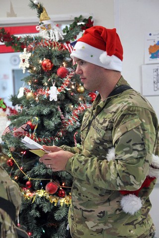 U.S. Army Sgt. Jarrod Hogan stands in front of a Christmas tree ready to sing Christmas carols for the patients and staff at Staff Sgt. Heathe N. Craig Joint Theater Hospital, Dec. 24th. Hogan and other Soldiers visited the hospital to sing to the patients and staff in hopes to raise the Christmas spirit. (Photo by U.S. Army Spc. Kristina L. Gupton, Task Force Red Bulls Public Affairs)