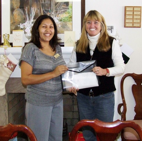 Terrie Williams, (r) Executive Director of Crisis 211, accepts a bag of money totaling over $750.00 from Yasmine Carrion,  Community Relations Specialist for Daymar Institute. (Photo by Art Conn)