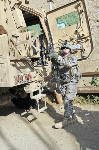 U.S. Army Spc. Cristine Gallagher of Victorville, CA, machine-launched grenade gunner for the 64th Military Police Company based at Combat Outpost Fortress, prepares her weapon for a foot patrol through the Noor Gal District Jan. 3rd. (Photo by U.S. Air Force Capt. Peter Shinn/RELEASED)