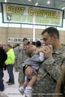 A soldier feeds his new baby for what is likely the first time.