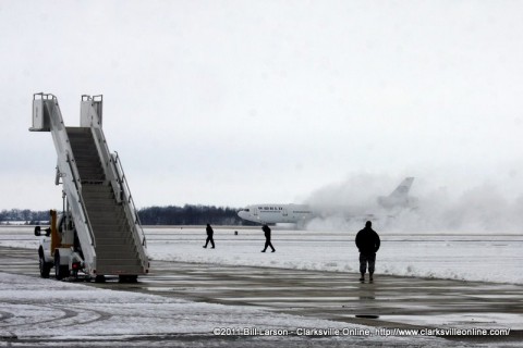 The airplane lands in a cloud of blown snow