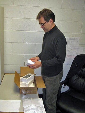 Dr. John Nicholson, assistant professor of computer science and information technology at Austin Peay State University, sorts through cell phones purchased for a new course in mobile app development being offered this spring. (Photo by Dr. Bruce Myers, APSU Department of Computer Science and Information Technology)