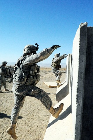 U.S. Army Soldiers from 4th Brigade Combat Team, 101st Airborne Division, maneuver over an obstacle as part of the “stress shoot” at Forward Operating Base Sharana Jan. 9th. (Photo by U.S. Army Sgt. Luther L. Boothe Jr., Task Force Currahee Public Affairs)