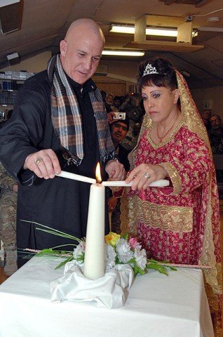 Tony Humphreys of Pittsburgh, and Lisette Bonano of Tampa, FL, light the unity candle during their marriage commitment ceremony at Forward Operating Base Lightning Feb. 7th. (Photo by U.S. Air Force Tech. Sgt. Maritza Freeland, 17th Public Affairs Detachment)