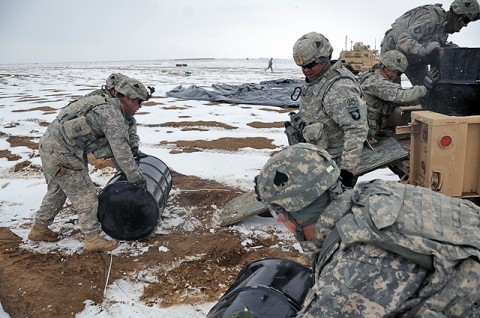 Soldiers from 4th Brigade Combat Team, 101st Airborne Division, roll barrels of fuel into a vehicle Jan. 30th. The barrels were dropped as part of a container delivery system, an alternative supply delivery system in which an aircraft flies low to the ground and releases cargo on pallets from the back of the aircraft cargo area. (U.S. Army photo by Spc. Kimberly K. Menzies, Task Force Currahee Public Affairs)