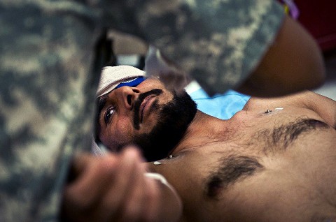 An Afghan man simulates a penetrating eye injury during a recent mass-casualty exercise as a medic checks his condition at Forward Operating Base Bostick in eastern Afghanistan Feb. 2nd. (Photo by U.S. Army Staff Sgt. Mark Burrell, Task Force Bastogne Public Affairs)