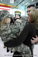 A young girl takes a photo of her mom and dad after they were reunited at the Welcome Home Ceremony