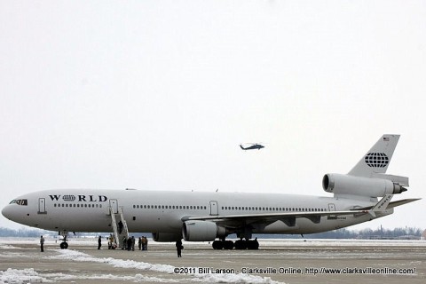 An Army Helicopter flies over the airfield as families wait for their soldiers to begin to disembark from the aircraft.