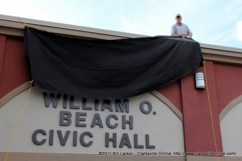 A county worker unveils the name of the re-dedicated Civic Hall