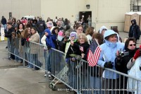 Deb Turbeville stands in the crowd waiting for her son to get off the plane. (light blue coat with flag)