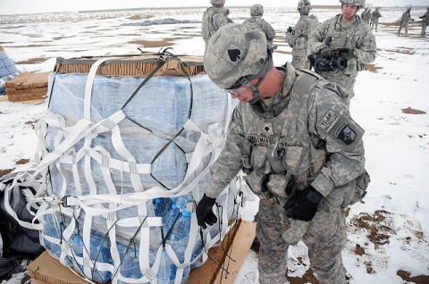 U.S. Army Spc. Robert Smallman of Chino, CA, inspects a bundle of water that was dropped from a C-17 Globemaster III during a recent container deliver system mission to the remote Forward Operating Base Waza Kwah in eastern Afghanistan Jan. 30th. (Photo by U.S. Army Sgt. 1st Class Pete Mayes, Task Force Lifeliners Public Affairs)