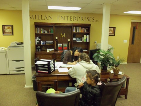 Jil Simpson signing her new lease in the offices of Milan Enterprises