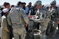 U.S. Army Spc. Stephen Hirt, an imagery analyst with Task Force Currahee, Company B, 4th Brigade Special Troops Battalion, 4th Brigade Combat Team, 101st Airborne Division, a native of Anaheim, CA, and member of the Islamic faith, hands out school supplies donated by his mosque in California to Afghan children in a village west of Forward Operating Base Sharana, March 14th. (Photo by U.S. Army Sgt. Christina Sinders, Task Force Currahee Public Affairs)