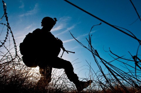 Silhouetted by the rising sun, a Soldier with Task Force No Slack, steps over concertina wire after leaving a mountaintop observation post during a 12-hour combat patrol in Chowkay District's Dewegal Valley in eastern Afghanistan's Kunar Province March 13th. The area was a known Taliban hideout and the Soldiers were engaged periodically throughout the day. (Photo by U.S. Army Sgt. 1st Class Mark Burrell, Task Force Bastogne Public Affairs)