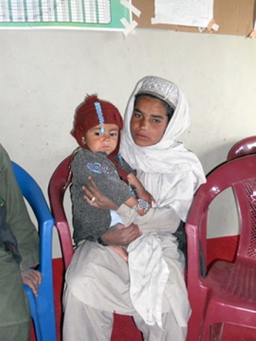 A 10-year-old boy holds his injured brother in the waiting room of a make-shift clinic. The boy’s burned hand was treated by Afghan National Army medics and doctor during a 4th Brigade Combat Team, 101st Airborne Division, Task Force Currahee and the ANA 203rd Corps, Combined Medical Assistance Team trip to Marzak, March 15th. (U.S. Army Photo)