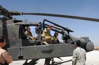 Chief Warrant Officer 2 Elizabeth Kimbrough – an AH-64 Apache pilot – and Capt. Donna Buono (middle) – the commander of Company B, 3rd Battalion, 101st Aviation Regiment, and an AH-64 Apache pilot – introduce Afghan air force Maj. Gen. Abdul Razik Sherzai, the commander of the Kandahar Air Wing, to the helicopter during the general’s visit with Task Force Thunder here April 2nd. (Photo by Sgt. 1st Class Stephanie Carl)