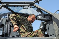 Afghan air force Maj. Gen. Abdul Razik Sherzai, the commander of the Kandahar Air Wing, climbs into the cockpit of an AH-64 Apache helicopter during a visit with Task Force Thunder here April 2nd. Sherzai met with Col. Todd Royar – the commander of the Regional Command South rotary wing asset – and his subordinate leaders to discuss future partnering opportunities between their two units. (Photo by Sgt. 1st Class Stephanie Carl)