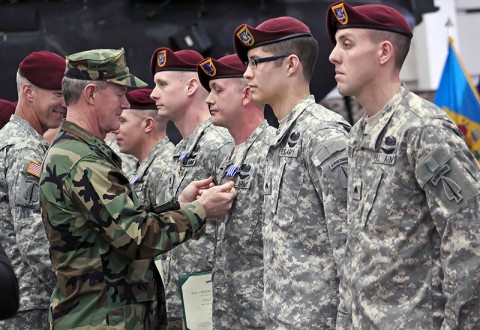 Navy Vice Adm. William H. McRaven, center left, commander of the Joint Special Operations Command, pins the Distinguished Flying Cross on Sgt. Jeremy Gribbles, center right, 160th Special Operations Aviation Regiment (Airborne) who was among eight Night Stalkers of 160th SOAR to receive the award during a ceremony at Joint Base Lewis-McChord, WA, April 11th. (Photo by Spc. Ashley M. Outler, 28th Public Affairs Detachment)