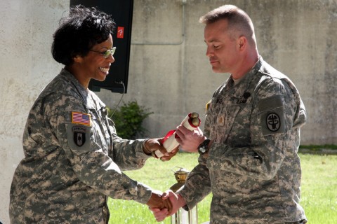 Blanchfield Army Community Hospital Deputy Commander for Nursing Col. Joy Napper hands a scroll containing the Nursing Creed to Maj. Dale Vegter, Chief of Department of Surgery's Clinical Services. The symbolic gesture during the Army Nursing System of Care kickoff ceremony April 6 was part of nurses' renewed dedication to their professional values.