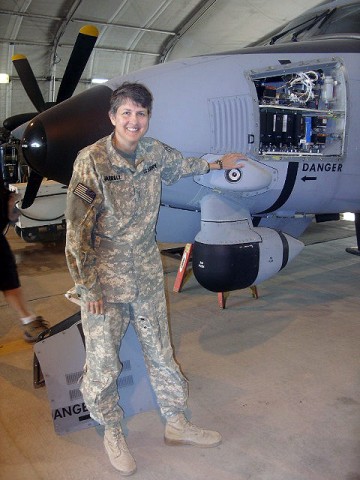 U.S. Army Chief Warrant Officer 5 Cathy Jarrell poses next to a C-12 aircraft. (Photo by U.S. Army Spc. Morgan McAfee, Task Force Falcon)